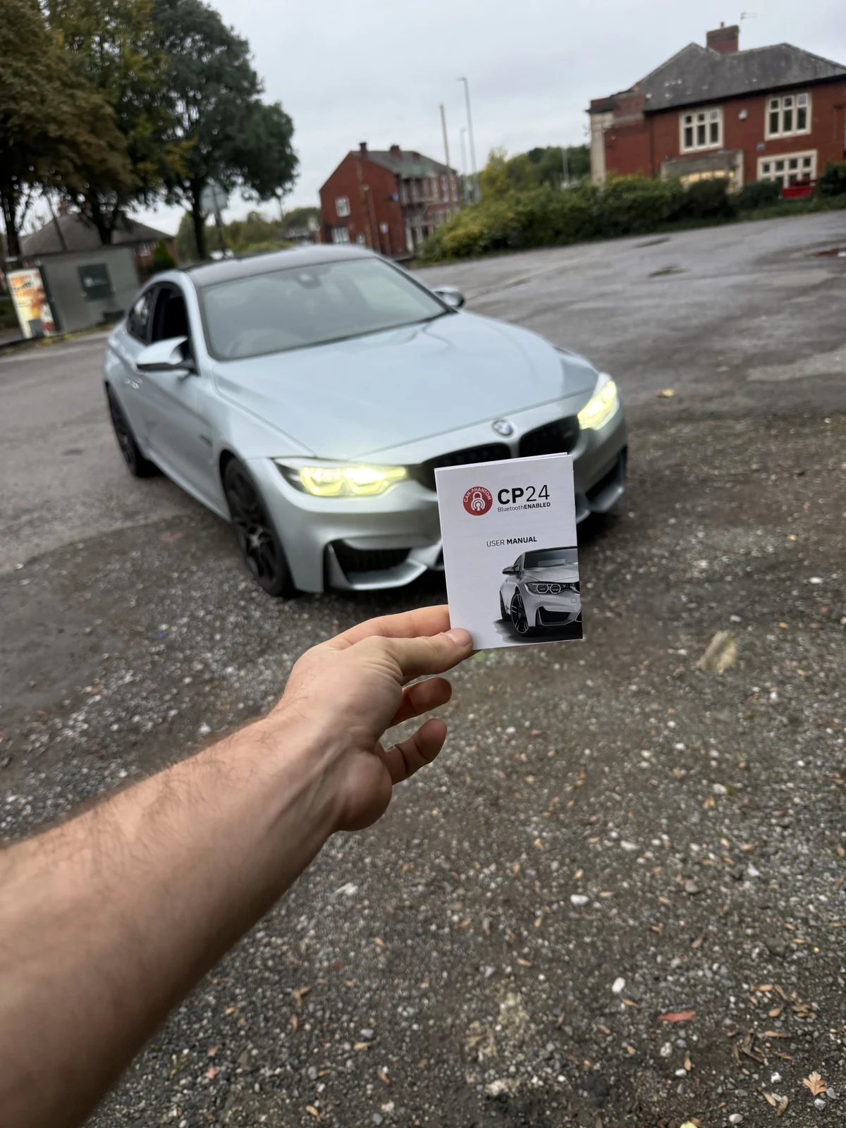 A CP24 booklet held in front of a silver BMW, supplied by Brandon