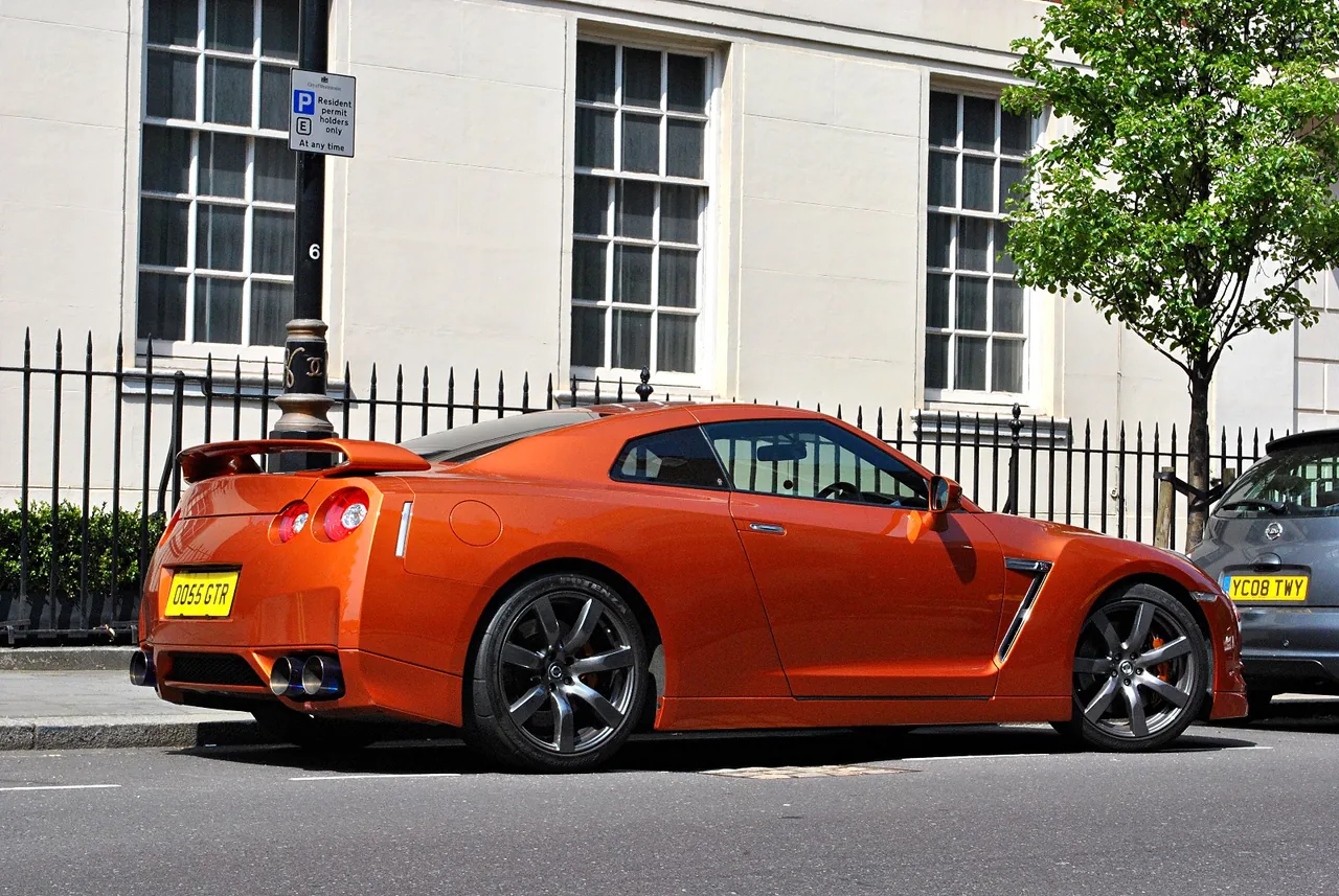 Orange Nissan GT-R on a London street with white townhouses